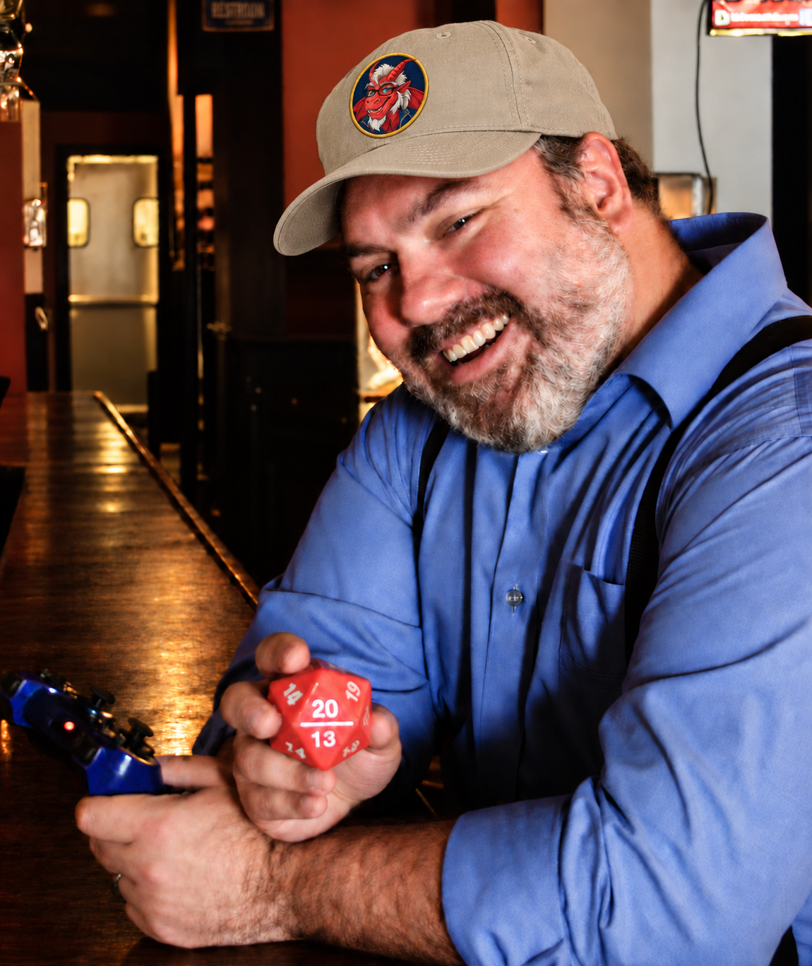 Lex wearing a beige cap with his dragon emblem, smiling and holding an oversized red twenty-sided die at The Chromatic Dragon
